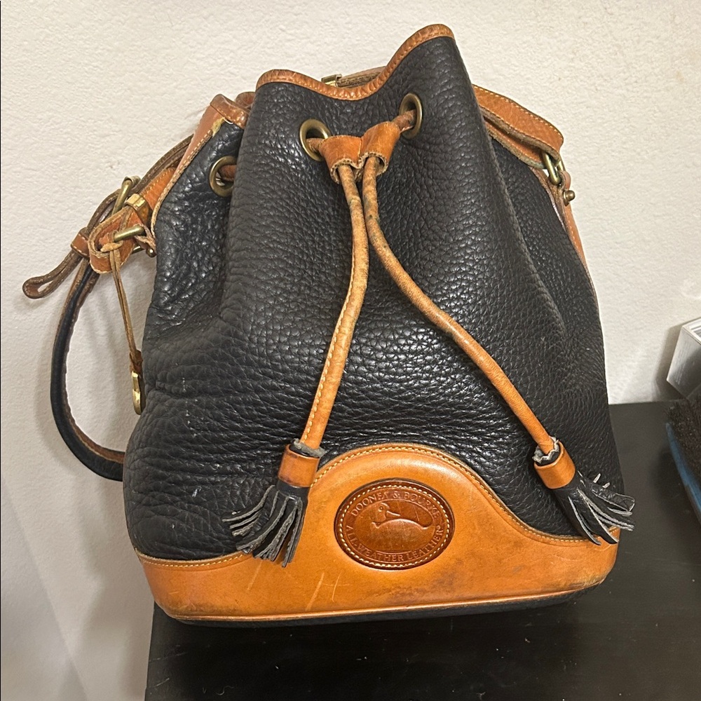 Dooney & Bourke Black and Tan Pebbled Leather Drawstring Bucket Bag